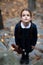 Beautiful lonely little girl with with pigtails, dressed in dark blue standing near mystic abandoned building with gothic stairs