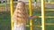 Beautiful long blonde hair girl holds yellow leaves on nature background. Smiling child plays in autumn park sunny day