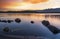 Beautiful long exposhure sunset landscape . The small lake with stones in the water, beautiful panorramic viwe on the mountais aft