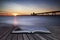 Beautiful long exposure sunset over ocean with pier silhouette c