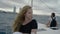 A beautiful long-haired girl sits on the bow of a barred yacht and enjoys life smile. The blonde is resting in the open sea or
