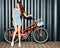 Beautiful long-haired leggy girl asian in summer outfit posing with a vintage red bicycle. Night shot. Look at camera.