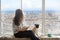 Beautiful long haired woman with her dog enjoying Barcelona Spain view outside the window
