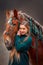 Beautiful long-haired  young woman  with red tinker horse in christmas decor