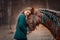 Beautiful long-haired  young woman  with red tinker horse in christmas decor