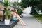 Beautiful long-legged cute model girl sitting on the terrace of a summer cafe