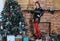 Beautiful long legged redhead girl in red stockings and heels  posing in Christmas decoration