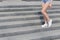 Beautiful long, slender legs girls in sneakers and denim shorts on the stairway summer day