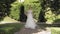 Beautiful lovely stylish bride in white wedding dress and veil walking in park and waiting for groom