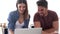 Beautiful lovely young couple using their laptop and talking in the kitchen at home.