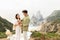 Beautiful loving european couple opening a champagne bottle, having romantic date with beautiful view on ocean shore