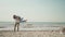 beautiful luaghing joyful man and woman ambracing on beach at seaside and man puts his girlfriend on hands and back