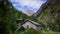 Beautiful lush mountain valley with old cottages and high alpine peaks behind