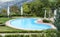 Beautiful luxurious swimming pool with crystal green waters in the garden