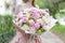 Beautiful luxury bouquet of mixed flowers in woman hand. the work of the florist at a flower shop. A small family