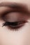 Beautiful macro shot of female eye with smoky makeup. Perfect shape of eyebrows