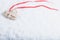 Beautiful magical vintage beige heart tied with a red ribbon on a white snow background. Winter and Christmas concept