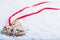 Beautiful magical vintage beige heart tied with a red ribbon on a white snow background. Winter and Christmas concept