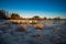 A beautiful majestic winter landscape of frozen seashore in a chilly sunny weather with clear sky horizon and pine trees