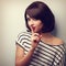 Beautiful makeup young woman showing silence sign. Short hair st