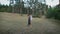 Beautiful man and woman embracing standing in a clearing in the middle of a pine forest.