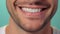 Beautiful mans smile with healthy white, straight teeth close-up on one tone background with space for text