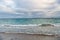Beautiful marine. Blue sea on cloudy sky background. Sea waves on sandy beach. Sea shore. Seascape. Sea voyage. Summer