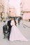 Beautiful married couple standing embracing in the old city with wonderful architecture