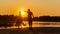 Beautiful mature couples dance on a wild beach in the rays of the setting sun