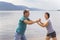 Beautiful mature sportive couple doing gymnastic exercises on the beach