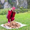 Beautiful mature woman in a sporting suit looks at a mountain of harvested mushrooms.