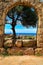 The beautiful Mediterranean sea through Roman ruins arch.