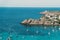 Beautiful Mediterranean sea view with small boats and a rocky shore with houses in Menorca, Spain