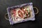 Beautiful meringue roll with fruit lies on a tray on a black background