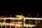 Beautiful mesmerizing night scene panoramic view of Linz Nibelungen bridge over Danube river with golden lights colorful reflexion