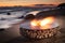 The beautiful metal round a fireplace stands on the sandy coast with a tidal wave at sunset, stones, sand, waves, the