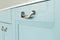 Beautiful metallic modern handle on a blue furniture facade. Close-up, selective focus