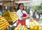 Beautiful mexican saleswoman with oranges on a farmers market