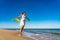 Beautiful mid adult woman walking, running on sunny beach