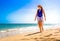 Beautiful mid-adult woman walking on sunny beach Santa Maria, Sal Island, Cape Verde