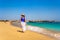 Beautiful mid-adult woman walking on sunny beach Santa Maria, Sal Island, Cape Verde