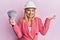 Beautiful middle age blonde woman wearing architect hardhat holding indian rupee celebrating achievement with happy smile and