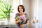Beautiful middle age woman decorating home with flowers