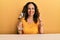 Beautiful middle age woman drinking a glass of white wine smiling with an idea or question pointing finger with happy face, number