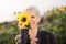 Beautiful middle age woman in a rural field scene outdoors standing between sunflowers