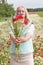 beautiful middle-aged blonde woman stands among a flowering field of poppies