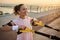 Beautiful middle aged sportswoman in pink t-shirt working out with suspension straps, enjoying bodyweight training outdoor in the