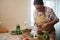 Beautiful middle aged woman, pleasant housewife pickling fresh harvested crop of organic cucumbers at home kitchen