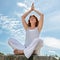 Beautiful middle aged woman praying in yoga position