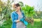 Beautiful middle aged woman with rooted hosta plant looking at camera